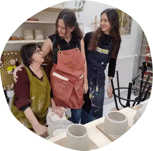 two women at a pottery workshop making clay pots